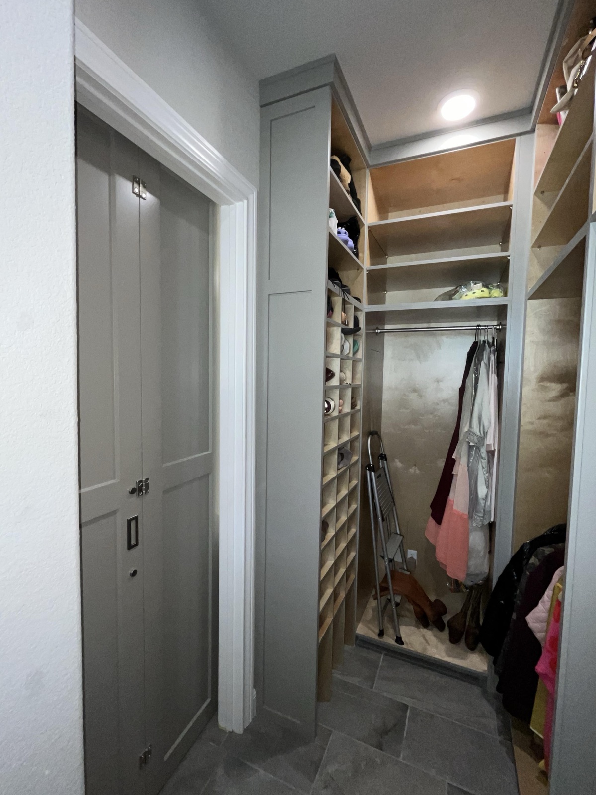 Bespoke walk-in closet system with shoe cubbies, hanging space, and paneled doors