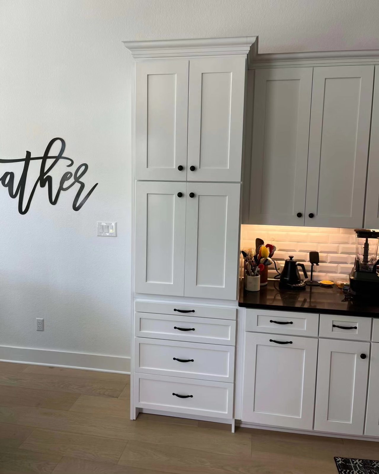 Custom kitchen island with integrated sink, appliances, and waterfall stone detailing