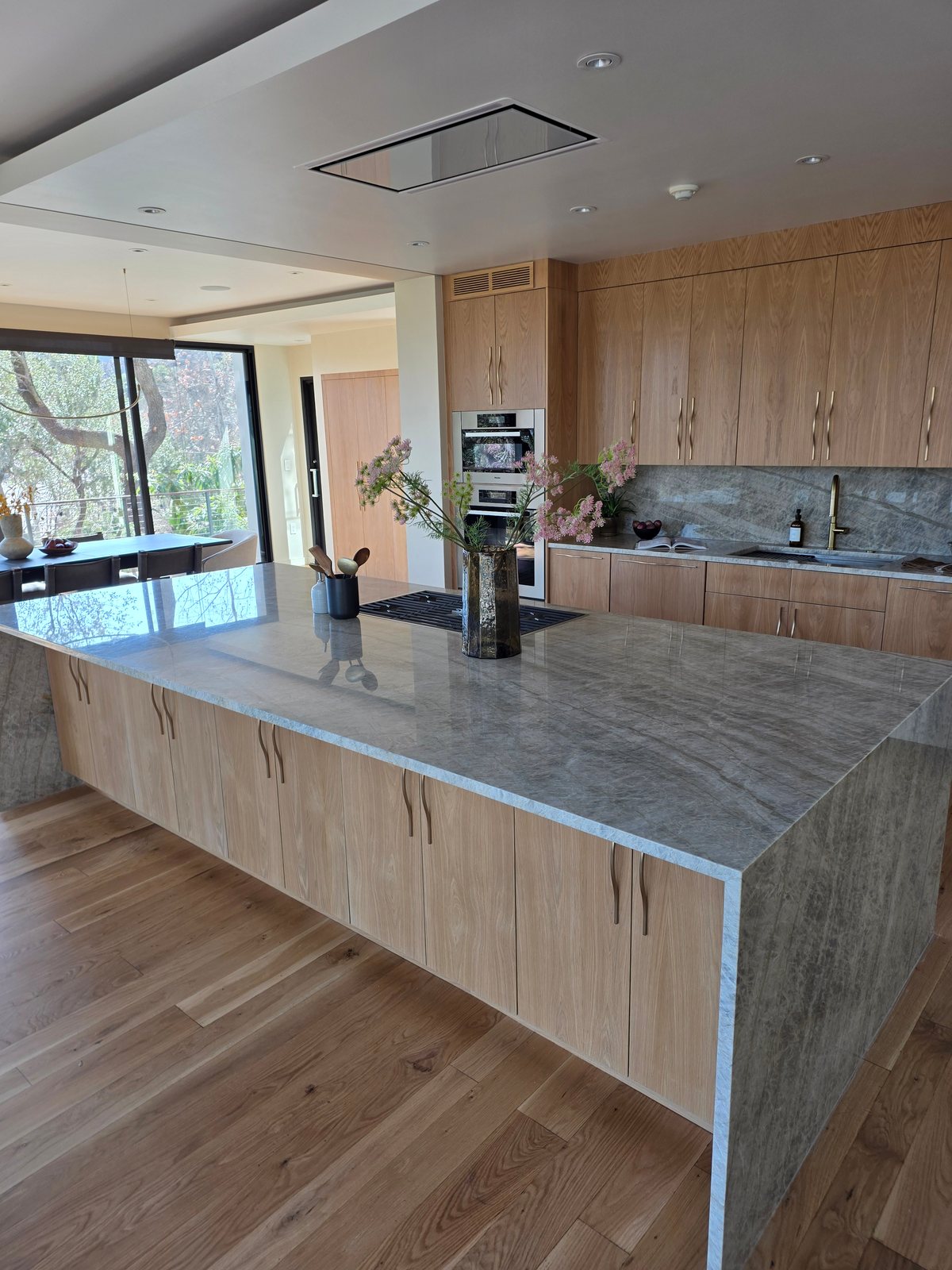 Custom kitchen island with waterfall-style stone and integrated storage
