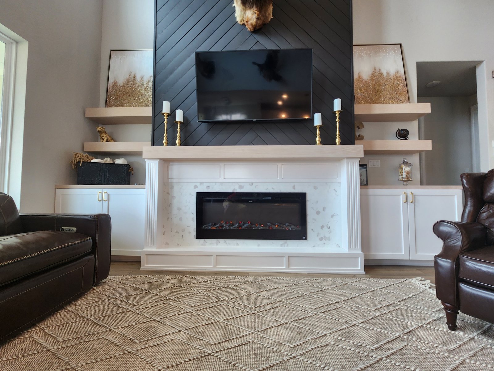Custom fireplace surround with built-in shelving, cabinetry, and integrated TV wall