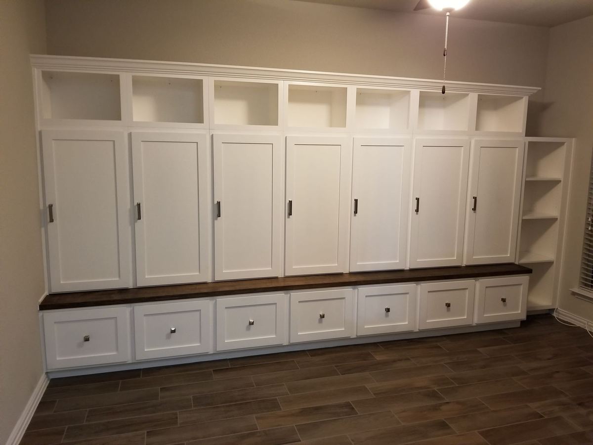 Completed mudroom installation with full-height lockers, bench seating, and integrated drawer base — finished install