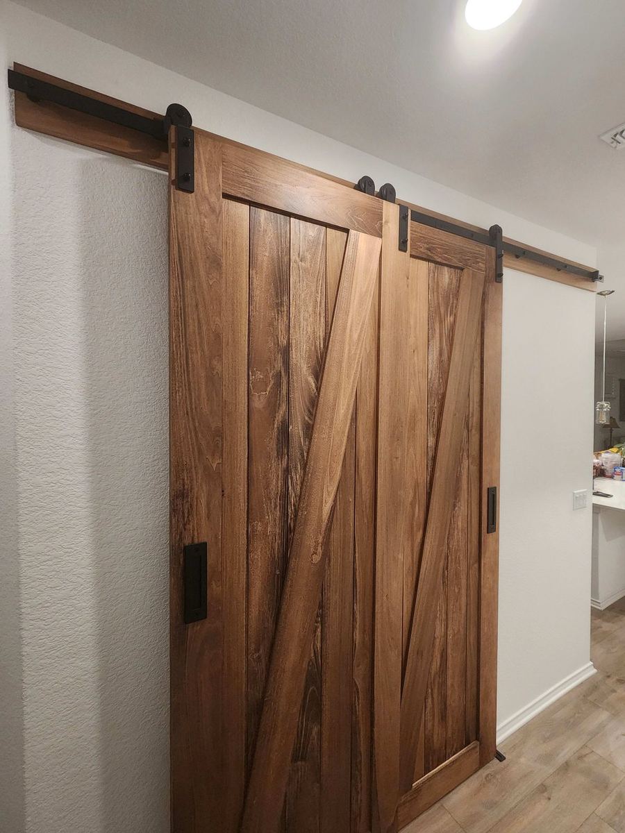 Custom stained barn-style sliding door with iron hardware — a one-off bespoke piece designed for the home